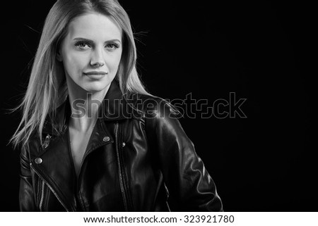 black and white fashion photo of beautiful sexy woman with luxurious curly hair in elegant jacket posing in studio