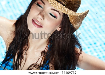Beautiful natural woman smiling in pool on summer vacations.