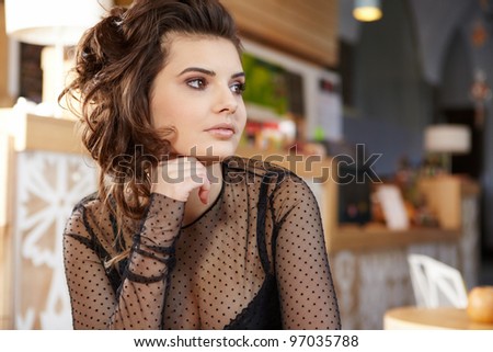 young woman sitting in the cafe with a cup of tea