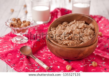 Breakfast with muesli, nuts and milk on the wooden table, selective focus