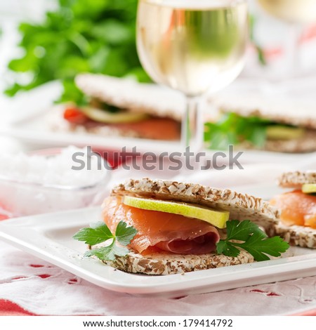 Smoked salmon with cereal bread, lemon and parsley, selective focus