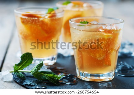 Fresh cocktail with orange, mint and ice, selective focus