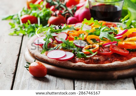 Vegan pizza with radish, tomato and paprika, selective focus