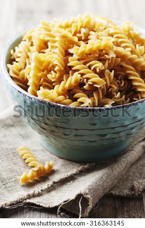 Integral raw pasta fusilli on the table, selective focus