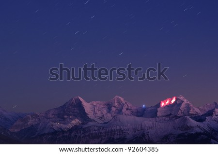 THUN, SWITZERLAND - JAN 12: Swiss crosses being projected on the face of the Jungfrau as a part of the 100 year festivities of the Jungfrau railway on January 12, 2012 in Thun, Switzerland.