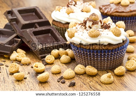 chocolate muffin with italian pastries called amaretti on wooden table