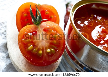 canned tomatoes  and  fresh cherry tomatoes on wooden table