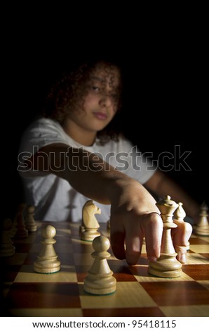 A young chess player moving the Queen