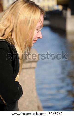 young woman looking down at water