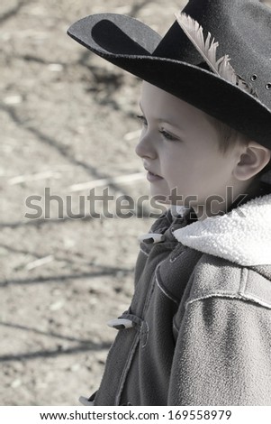 Young cowboy wearing a hat and fleece jacket