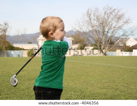 Toddler practising golf on the driving range