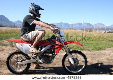 Young biker sitting on an off road bike, waiting to ride the track