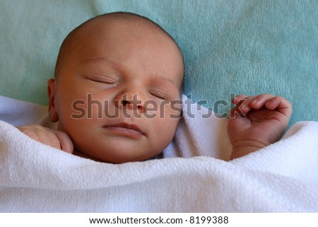 Week old baby boy on a blue blanket early in the morning