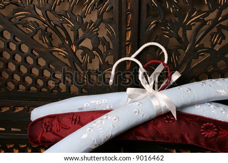 Blue and red cloth covered clothes hangers with needle work