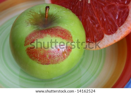 Sliced Pomelo and a green apple with a red kiss