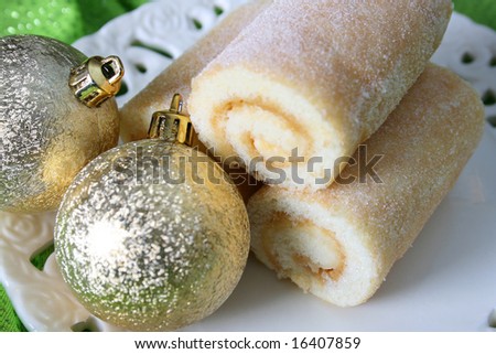 Christmas dessert, caramel Swiss roll and golden decorations