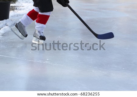 Legs of young child playing outdoor pond hockey