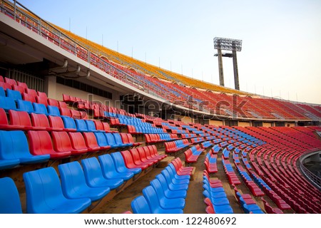 spotlight and seats, red and blue stadium seats curve rows on stadium with spot light pole