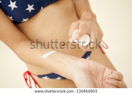 sun blocks, Asian woman bikini spraying sunblock lotion on her whist skin