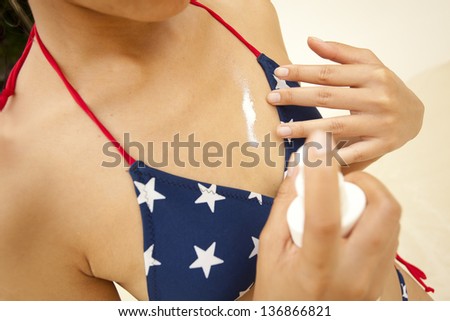 spray lotion, Asian woman bikini spraying sunblock lotion on her skin