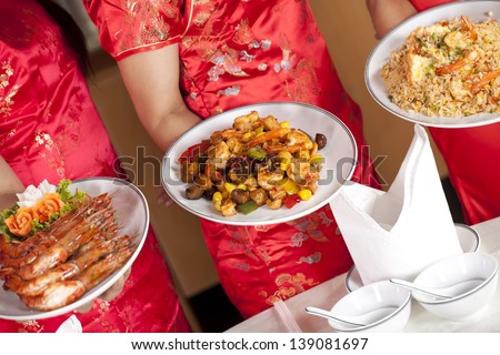 Chinese food, dishes of Chinese food with waitress holding dishes