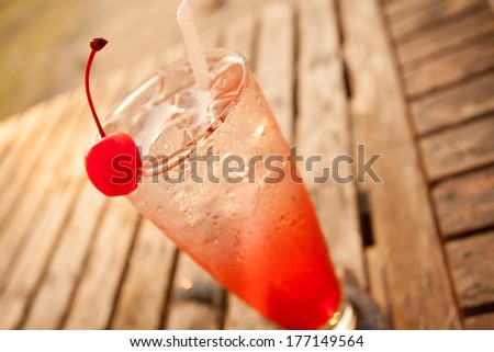 cocktail, red cocktail fruit decorate with cherry on wood table by the sea