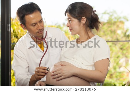 Pregnancy check, a male doctor using stethoscope check on pregnant woman