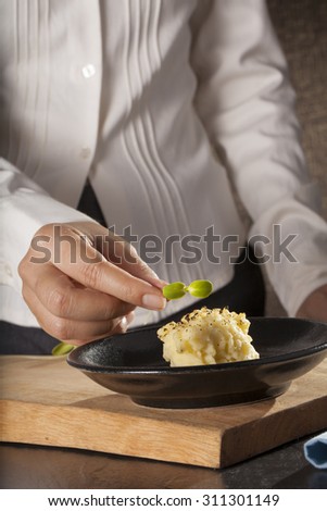 mashed potatoes, a dish of decorated mashed potatoes set with vegetable by a female chef hand