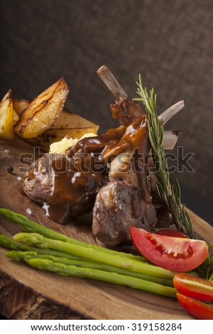 Rack of lamb steak, Rack of lamb steak cut in pieces decorate and seasoning with vegetable and herbs and red wine serve on chopping wood block