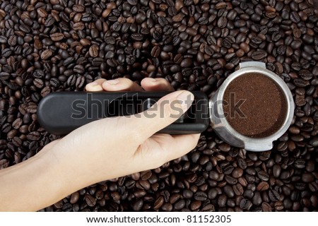 hold coffee scoop, female hand holding scoop full with grounded coffee.