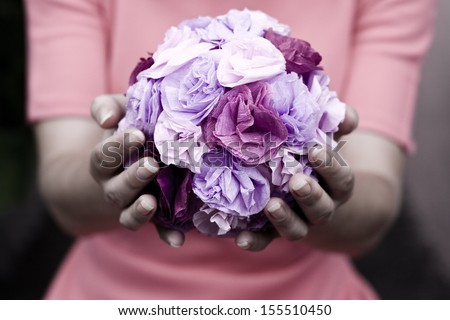 The girl in a pink dress holding a bouquet of purple flowers