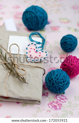 Old notebook with a dry branch of rosemary for love notes and bright balls of yarn