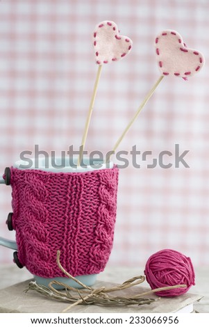 Blue cup in a pink sweater with felt hearts