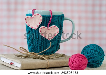 Blue cup in a blue sweater with felt hearts