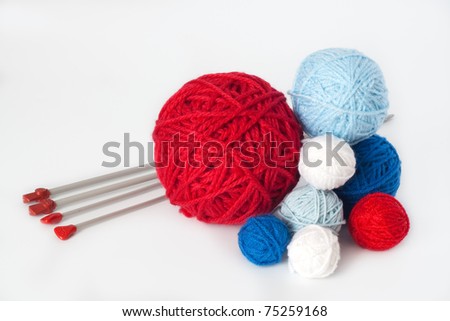 Red, white and blue balls of yarn for knitting and a lot of needle