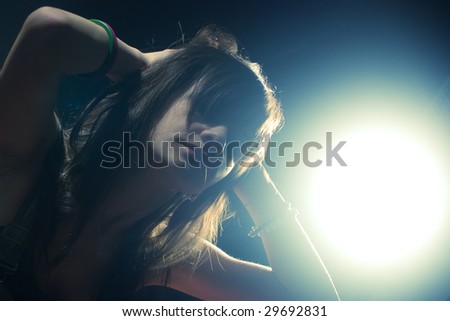 Portrait of a beautiful young woman with the light coming from behind, dramatic look