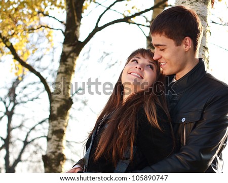 Happy young couple in love having fun autumn park on a bright sunny day