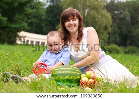 Love laughing family having picnic in summer park against blurred background of green nature