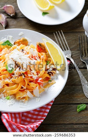 Italian pasta with seafood and parmesan on wooden boards