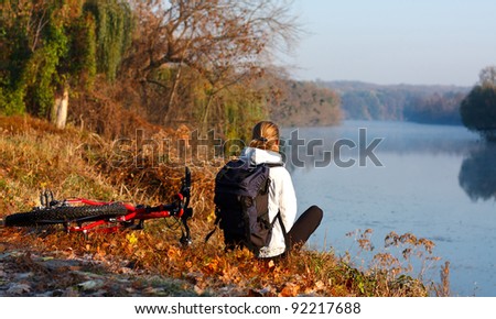 Woman cyclist enjoy the recreation on the river-side. Beautiful scenic view