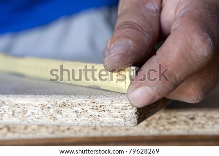 carpenter hands measuring a piece of wood