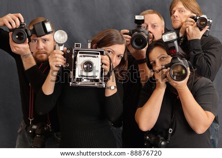 Photo of paparazzi waiting for the right moment to take photos. Focus on the two females in front.