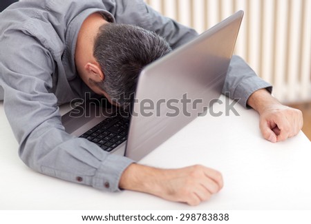 Image of a man sleeping at the working desk