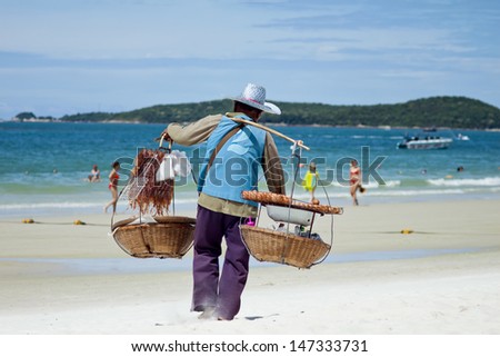SAMED ISLAND, THAILAND - JULY 14 : Unidentified man  sells seafood to tourists on the beach, Daily life of local people on island, JULY 14, 2013, Samed Island, Thailand.