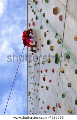 Youngster\'s effort in climbing a wall to reach the top.