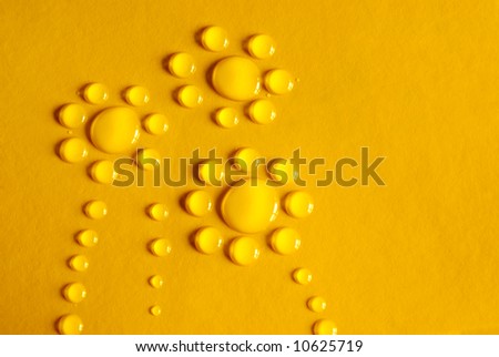 Water drops with the shape of three flowers in yellow background