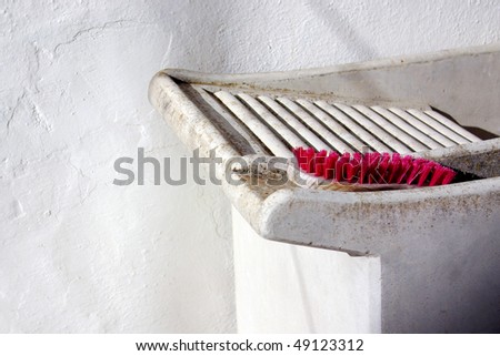 detail of a laundry handwashing tub with an old pink brush