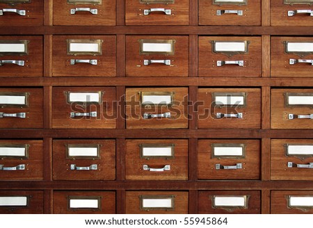 Rows of little drawers with white empty tags in an old furniture module