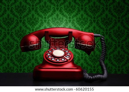 Red vintage phone on green background