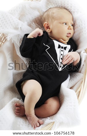 Overhead view of a 6-day old infant dressed up in his tux, but stuck in a basket.